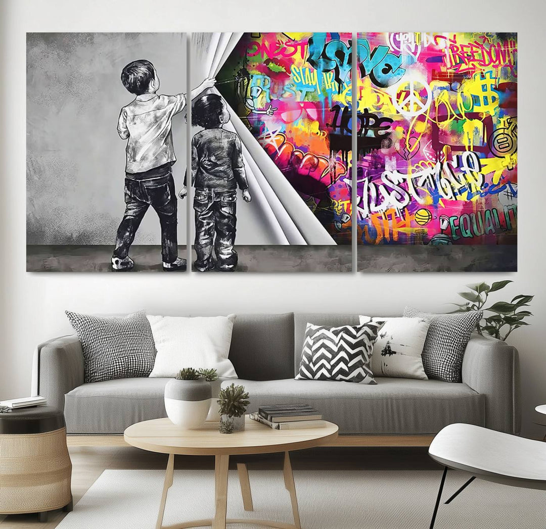 The Banksy Print - Street Art Canvas features a vibrant and bold image of two children lifting a curtain to reveal colorful graffiti. It's ready to hang, adding an urban modern decor vibe.