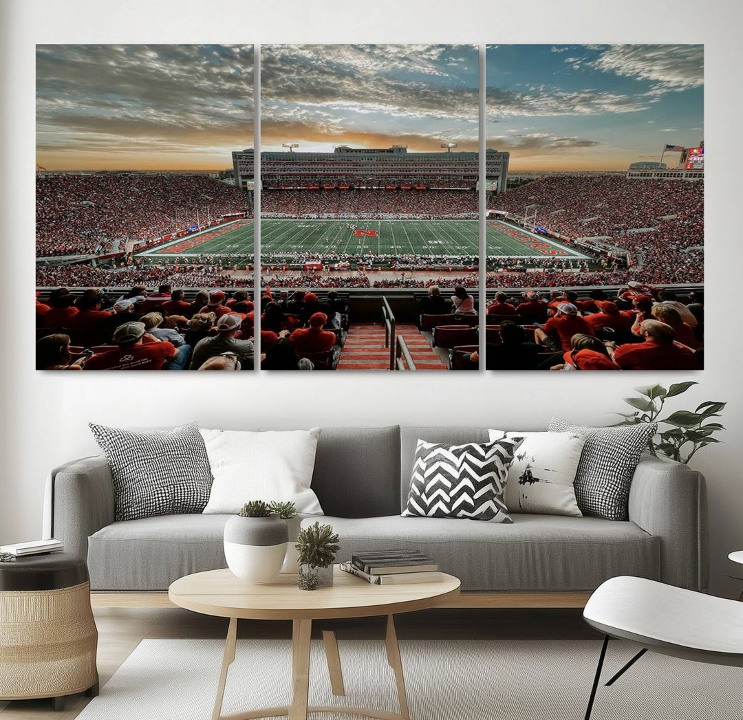 The living room features a stunning triptych of Lincoln Memorial Stadium wall art canvas print, celebrating the University of Nebraska Cornhuskers football team. This piece serves as captivating wall art, showcasing a gallery-quality finish.