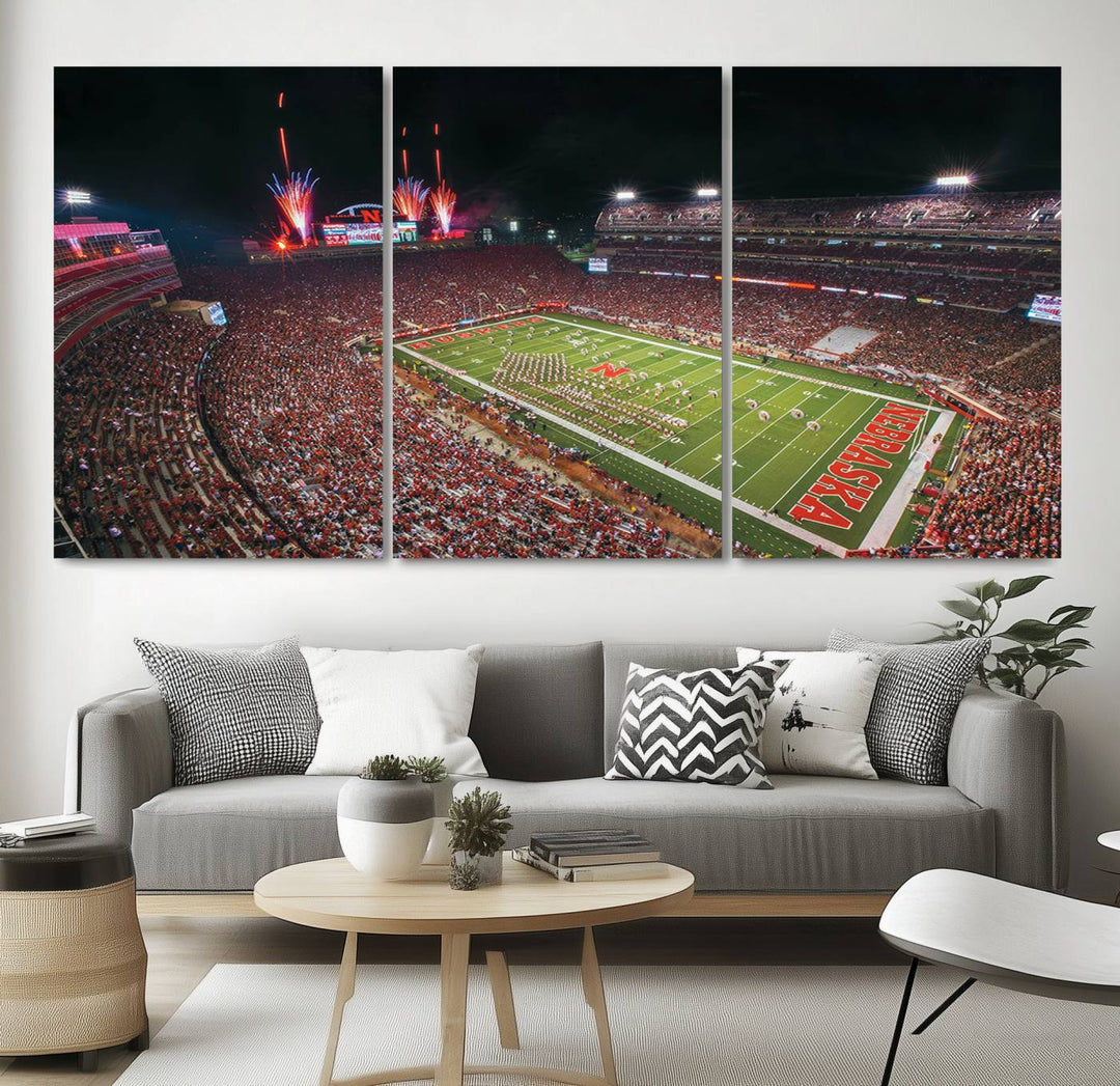 The University of Nebraska Cornhuskers Football Team Print, featuring Lincoln Memorial Stadium in a vibrant triptych canvas with fireworks above and a gallery-quality finish, is elegantly displayed.