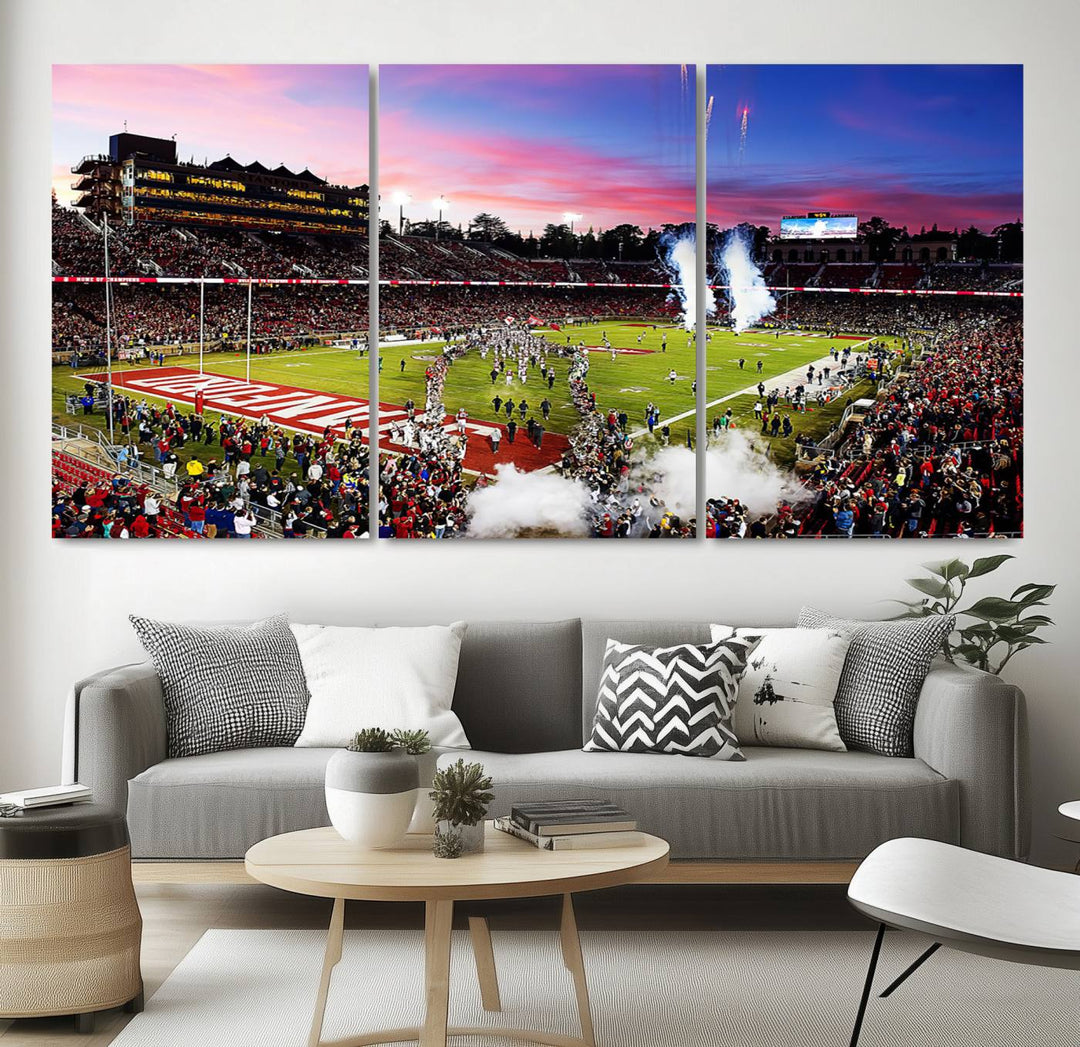 The wall art features a canvas print of the Stanford Cardinal football team, capturing players, fireworks, and smoke against the backdrop of a sunset at Stanford Stadium.