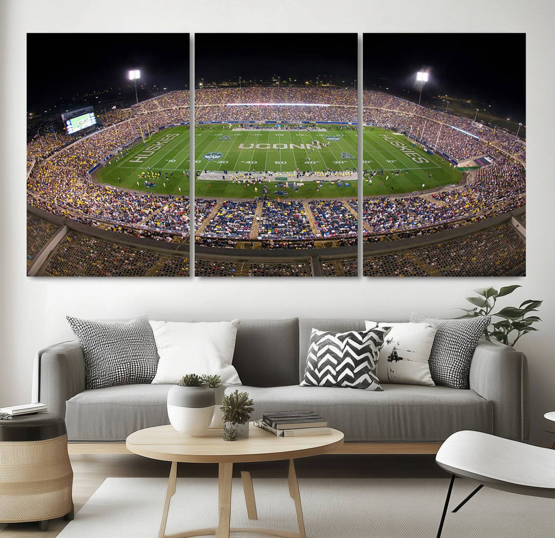 A large football stadium at night, featuring the UCONN Huskies, is depicted on the East Hartford Pratt & Whitney Stadium Wall Art Canvas Print.