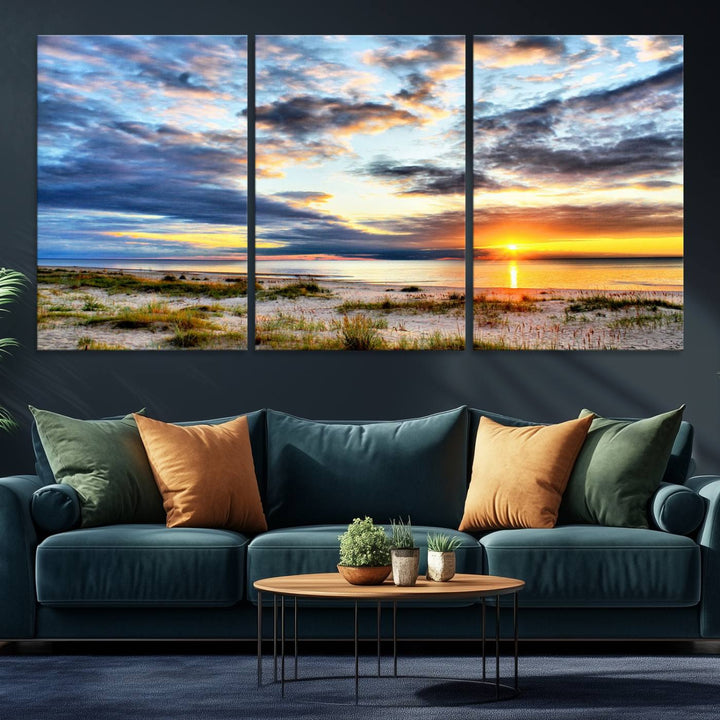 The Sunset On The Ocean canvas wall art features a beautiful beach sunset with grass and clouds.