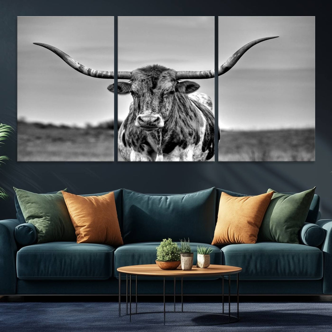 The Texas Longhorn Cow wall art, divided into three panels, is of gallery quality and displayed on a dark wall.