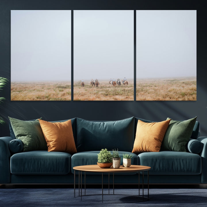 A group of horseback riders moving through a fog-shrouded field, evoking a calm Western scene with golden grasses and soft horizons.