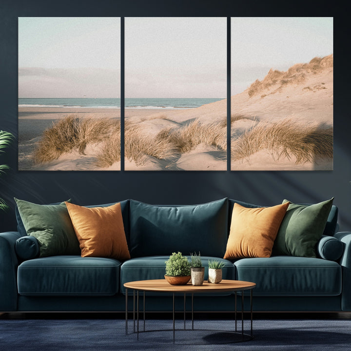 Soft pastel-toned beach scene with sand dunes, windswept grasses, and a calm ocean horizon, creating a serene coastal atmosphere.