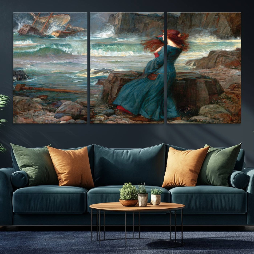 The Miranda by the Shore Wall Art Canvas Print depicts a woman in a blue dress standing by the sea, watching a shipwreck.