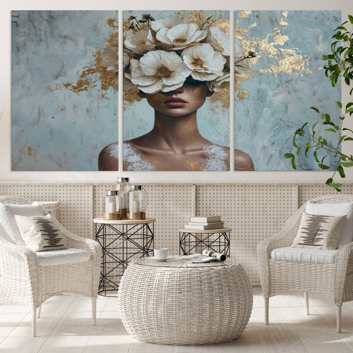 The Golden Petal Silhouette Woman Wall Art Canvas Print, a large 3-panel canvas with a textured gold floral design, serves as a luxurious centerpiece in modern glam settings. The artwork depicts a woman with flowers over her eyes against a textured background and hangs elegantly.