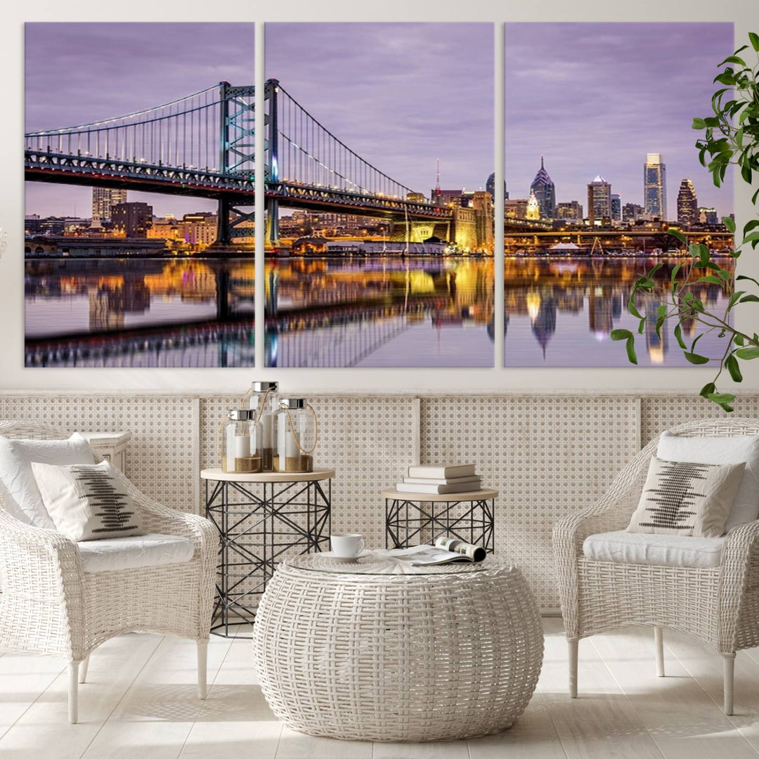 An Extra Large Wall Art Philadelphia Canvas Print, featuring a gallery-quality finish, captures the lit-up Ben Franklin Bridge and city buildings perfectly reflected on the water at sunset.