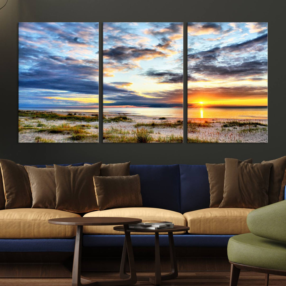 The Sunset On The Ocean canvas wall art features a beautiful beach sunset with grass and clouds.