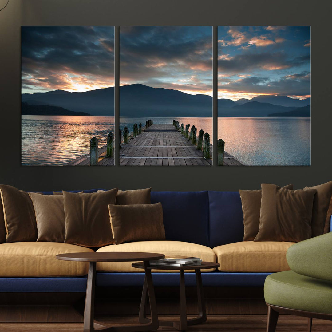 The Mountain Lake Wood Pier Canvas Wall Art depicts a serene lake and mountains, enhancing the beauty of any space.