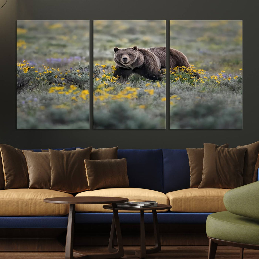 The "Grizzly 399 in Wild Flowers Wall Art Canvas Print" features a grizzly bear strolling through a field of yellow and purple flowers, beautifully showcased as a triptych. This handcrafted piece, proudly made in the USA, adds charm and sophistication to your space.