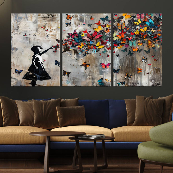 The Banksy Butterfly Girl 3-Piece Modern Graffiti Canvas Wall Art features a silhouette of a girl reaching for butterflies.