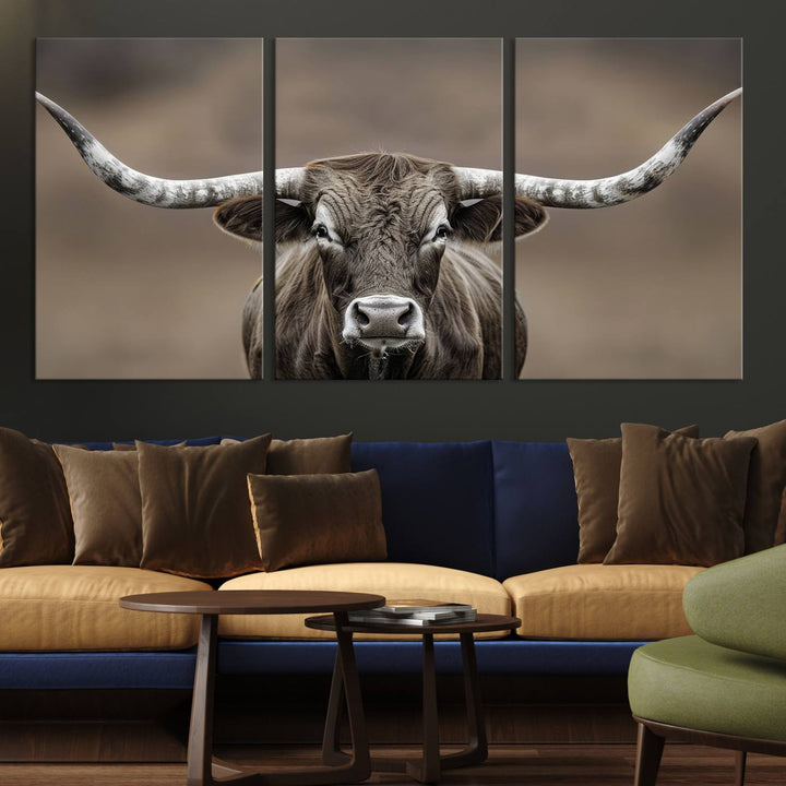 A close-up of a longhorn bull facing forward is featured in the Framed Texas Test-1, set against a blurred brown background.