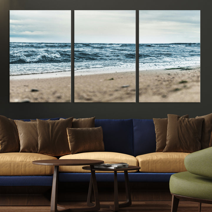 A moody ocean scene with gentle waves washing onto a sandy beach under a cloudy sky, creating a peaceful and coastal atmosphere.