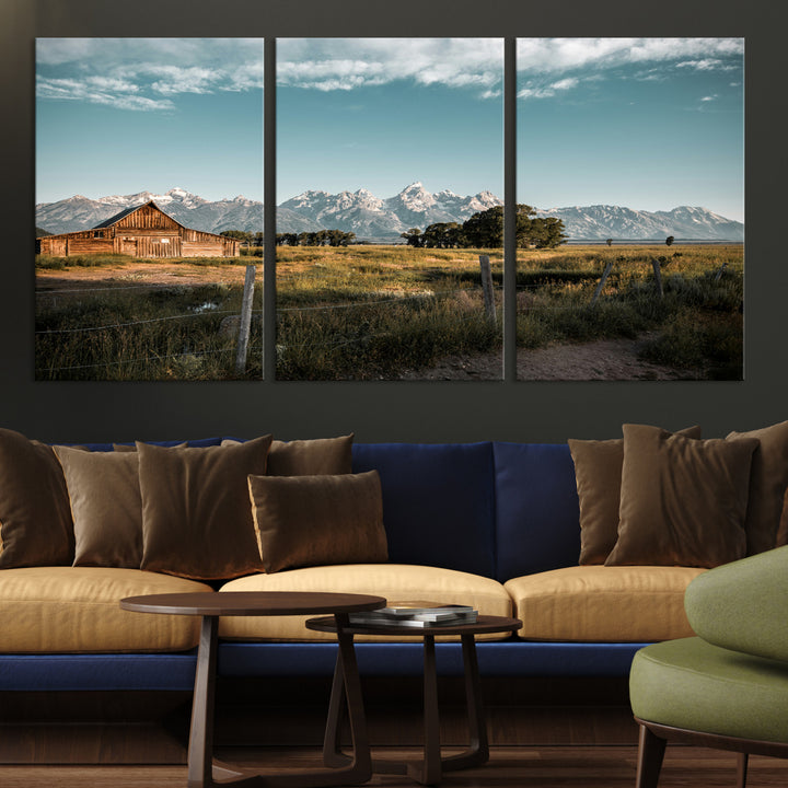 A rustic farmhouse with a wooden barn set against majestic mountain peaks under a soft blue sky, evoking peaceful countryside charm.
