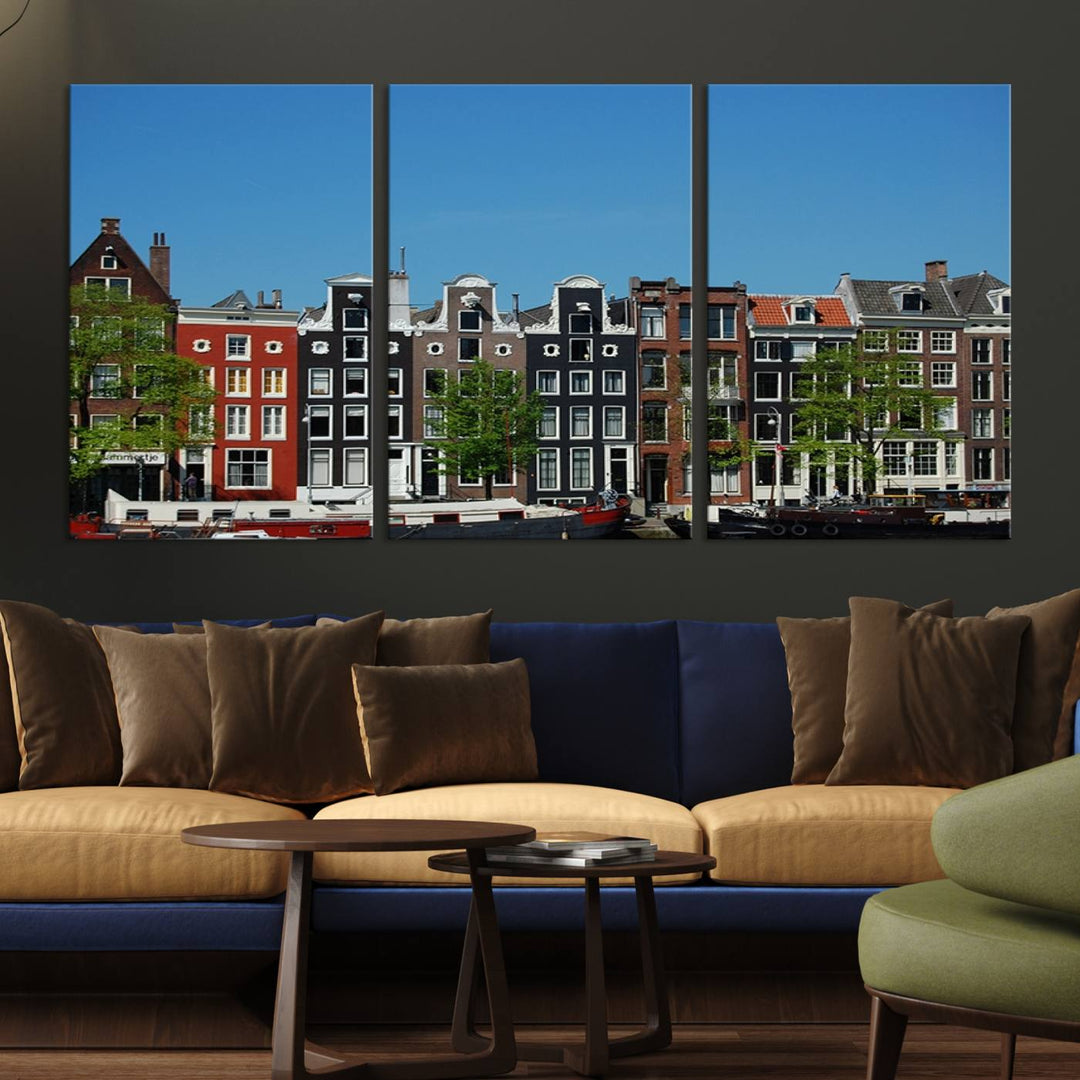 The Amsterdam City Wall Art Canvas Print showcases colorful traditional canal houses and boats set against a clear blue sky.