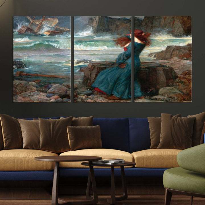 The Miranda by the Shore Wall Art Canvas Print depicts a woman in a blue dress standing by the sea, watching a shipwreck.