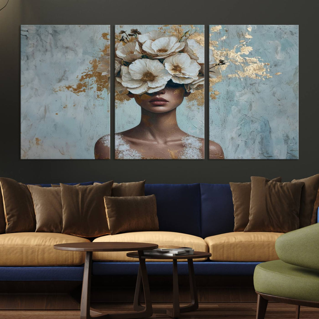 The Golden Petal Silhouette Woman Wall Art Canvas Print, a large 3-panel canvas with a textured gold floral design, serves as a luxurious centerpiece in modern glam settings. The artwork depicts a woman with flowers over her eyes against a textured background and hangs elegantly.