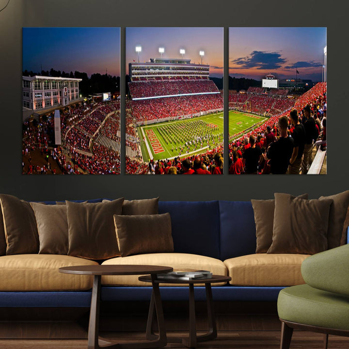 A print of a bustling Carter-Finley Stadium at dusk, featuring fans and a band, captures the essence of NC State Wolfpack football.