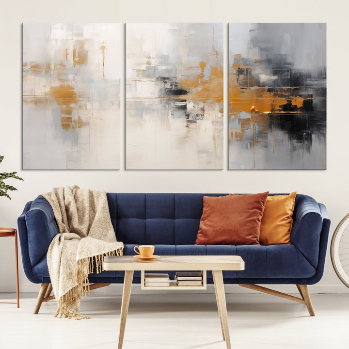 The Orange Pastel Abstract Wall Art Canvas Print, featuring a triptych of orange, white, and black hues, is elegantly displayed on museum-quality canvas.