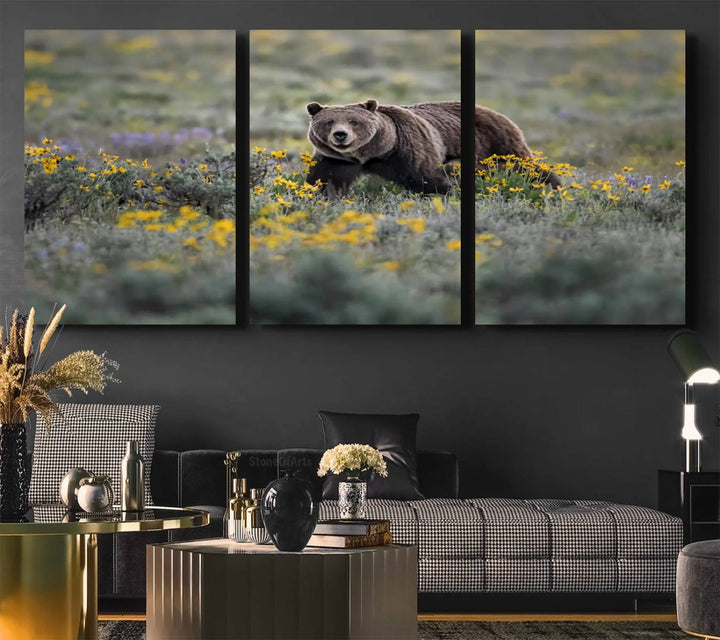 The "Grizzly 399 in Wild Flowers Wall Art Canvas Print" features a grizzly bear strolling through a field of yellow and purple flowers, beautifully showcased as a triptych. This handcrafted piece, proudly made in the USA, adds charm and sophistication to your space.