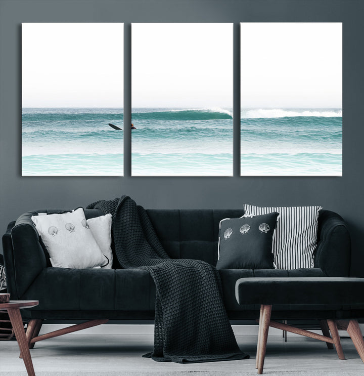 Minimalist photo of a lone surfer on calm aqua waves under bright sky, perfect for Scandinavian coastal or serene ocean-inspired home decor.