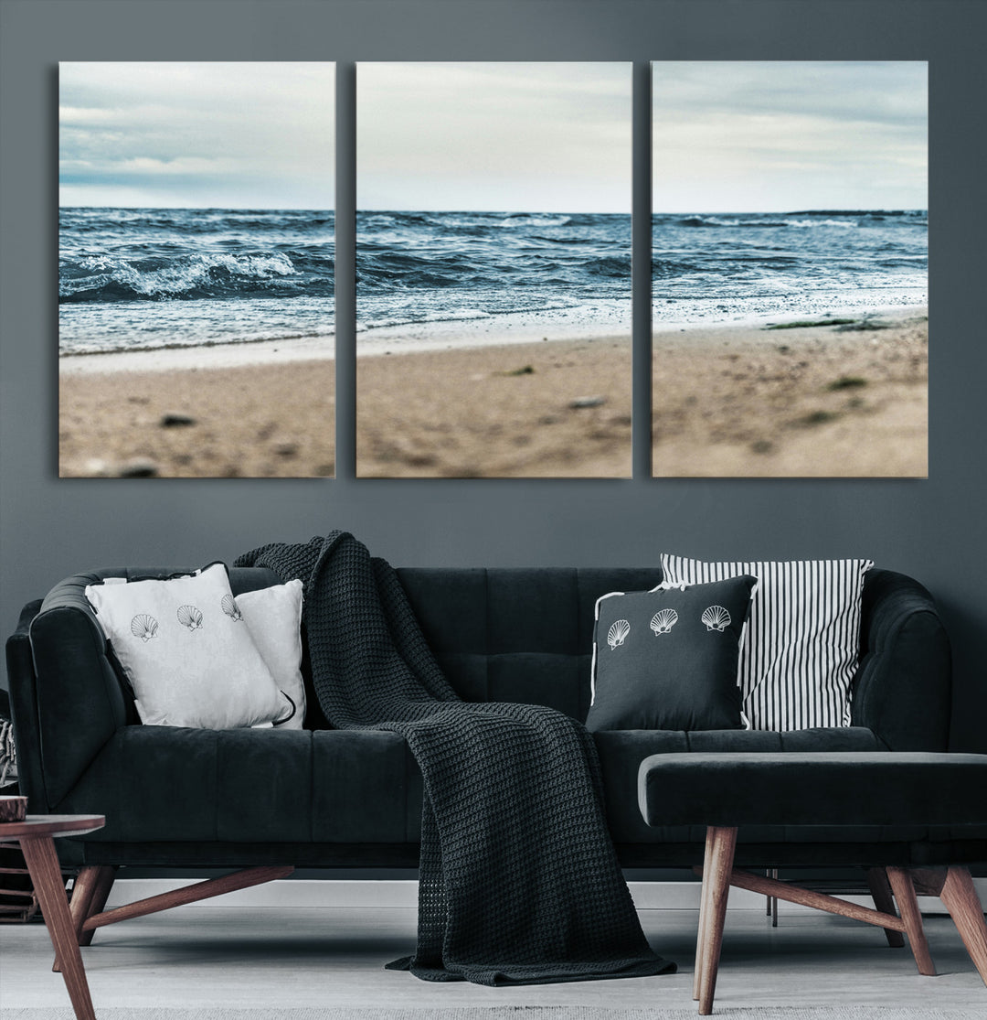 A moody ocean scene with gentle waves washing onto a sandy beach under a cloudy sky, creating a peaceful and coastal atmosphere.