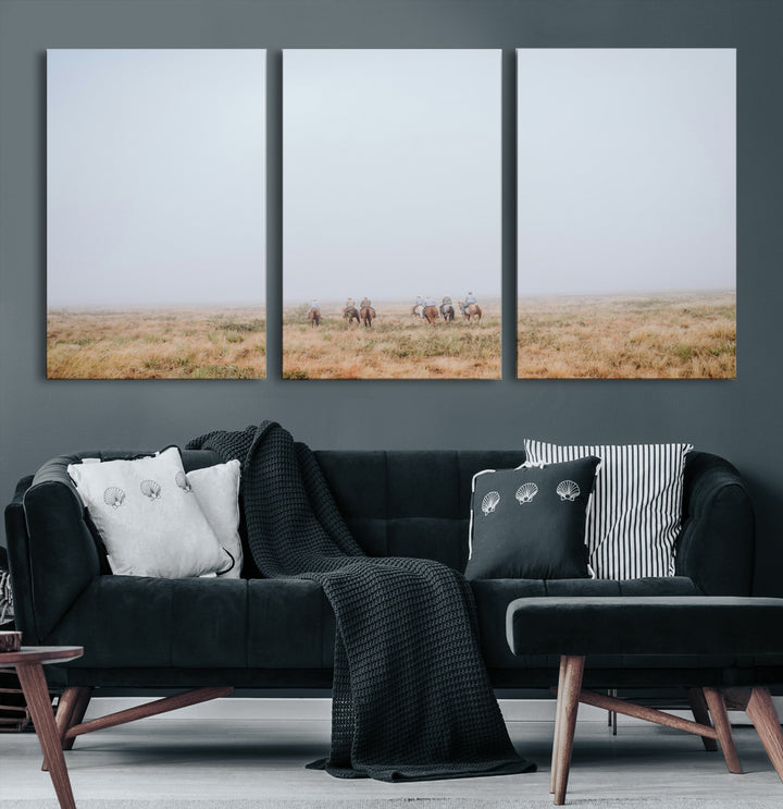 A group of horseback riders moving through a fog-shrouded field, evoking a calm Western scene with golden grasses and soft horizons.