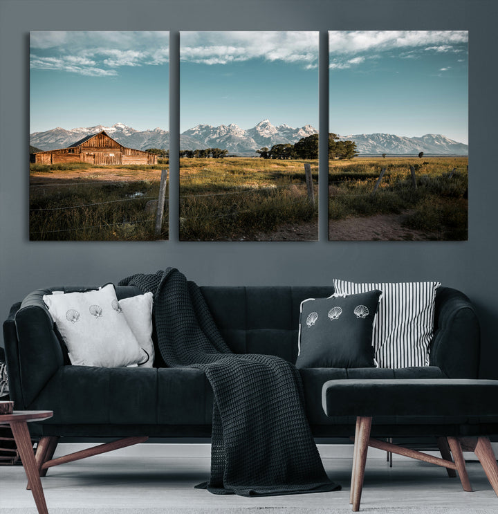 A rustic farmhouse with a wooden barn set against majestic mountain peaks under a soft blue sky, evoking peaceful countryside charm.