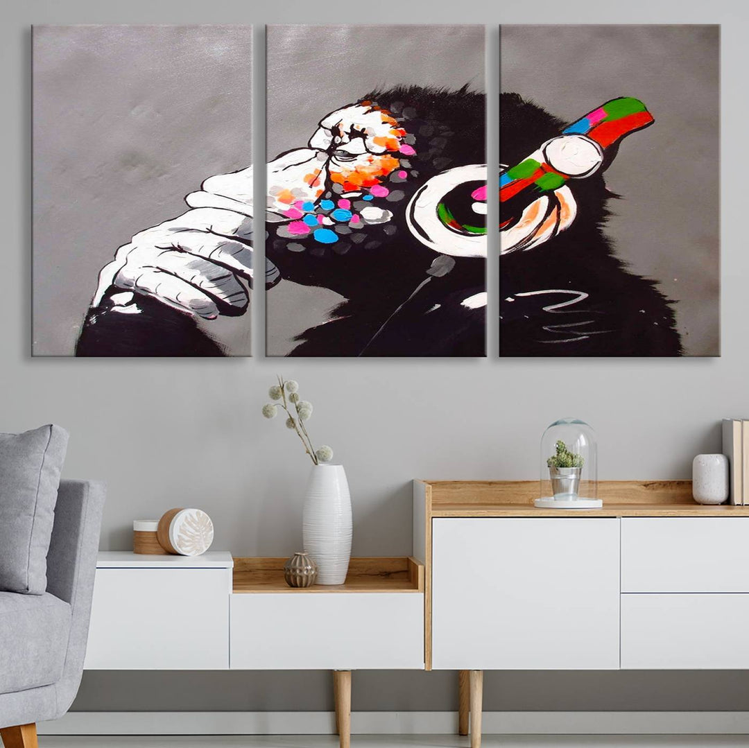 A vibrant triptych, the "DJ Monkey Listening to Music" wall art print, features a Banksy-inspired large canvas adorned with colorful modern pop art. This striking piece elegantly enhances the room with its dynamic and lively depiction.