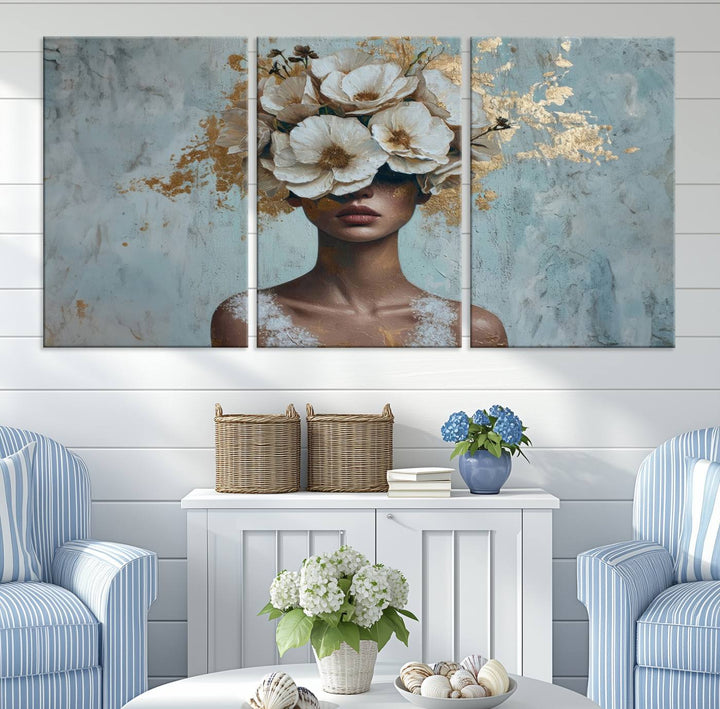 The Golden Petal Silhouette Woman Wall Art Canvas Print, a large 3-panel canvas with a textured gold floral design, serves as a luxurious centerpiece in modern glam settings. The artwork depicts a woman with flowers over her eyes against a textured background and hangs elegantly.