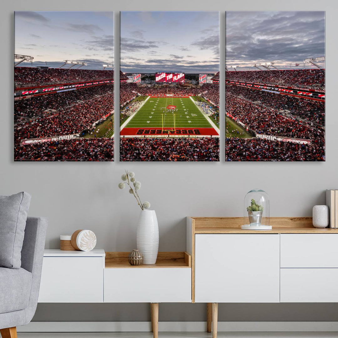 The wall art captures a stunning scene of Raymond James Stadium bathed in the warm hues of sunset. The sky, filled with clouds, provides a dramatic contrast to the vibrant lighting on the field, encapsulating the dynamic energy of a football game.