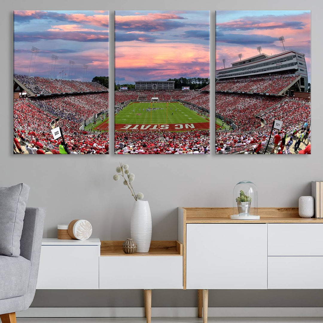 The wall art captures an NC State Wolfpack game under a vibrant sunset on triple canvas.