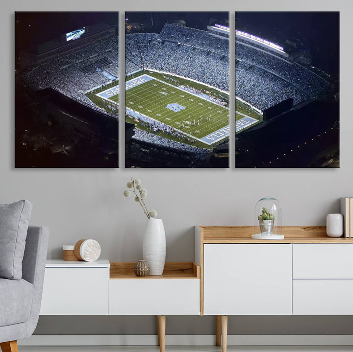 A University of North Carolina Tar Heels Football Team Print, showcasing Chapel Hill's Kenan Memorial Stadium, hangs in a modern dining room, adding a gallery-quality finish that enhances the entire space.