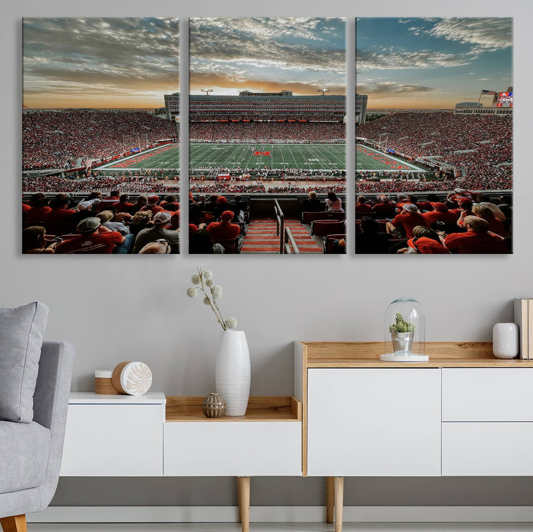 The living room features a stunning triptych of Lincoln Memorial Stadium wall art canvas print, celebrating the University of Nebraska Cornhuskers football team. This piece serves as captivating wall art, showcasing a gallery-quality finish.