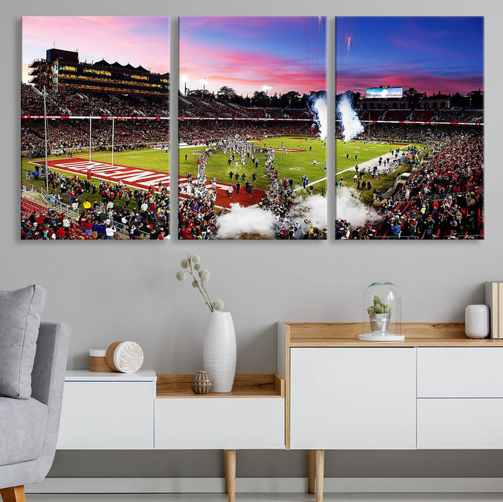 The wall art features a canvas print of the Stanford Cardinal football team, capturing players, fireworks, and smoke against the backdrop of a sunset at Stanford Stadium.