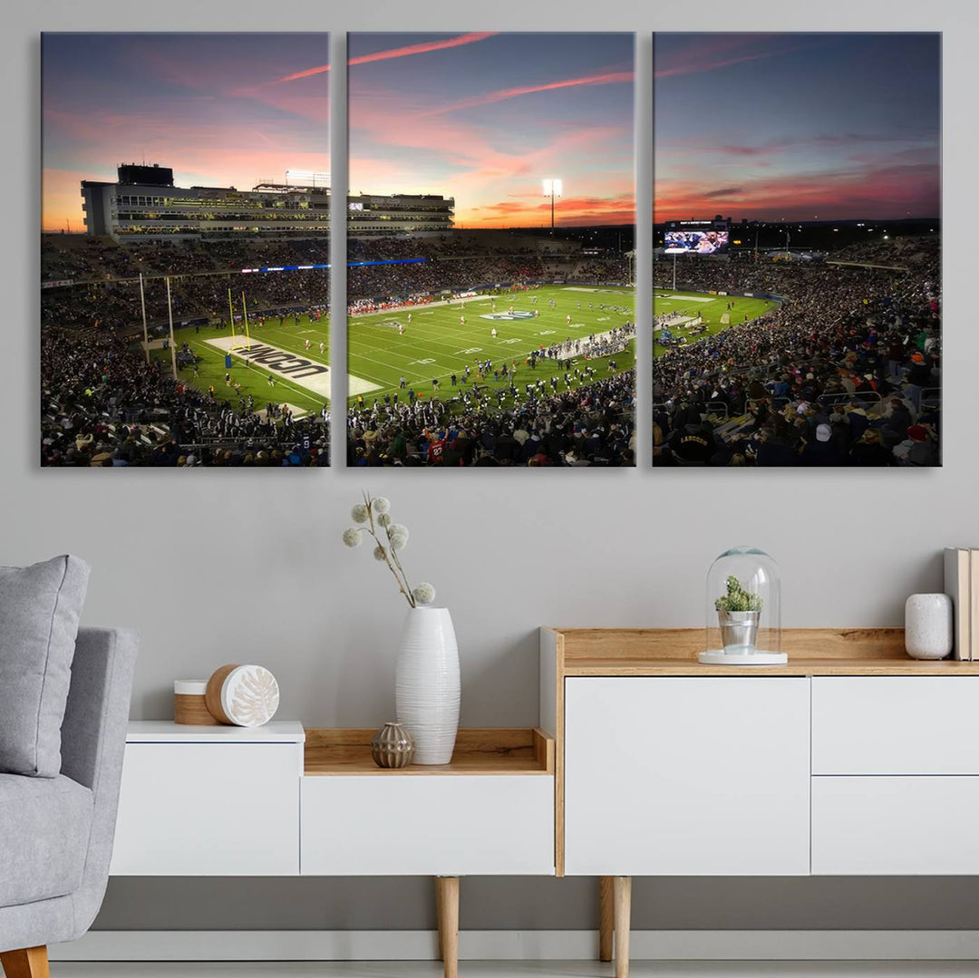 This wall art canvas print captures UCONN Huskies fans energizing a sunset scene at East Hartfords Pratt & Whitney Stadium.