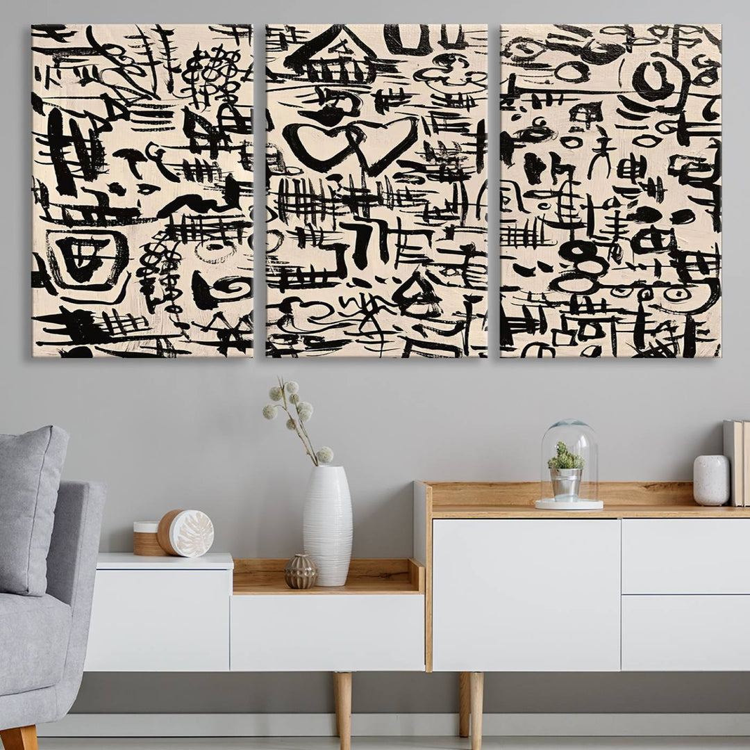 The Abstract Love and Chaos canvas is a museum-quality print featuring black symbols on a beige background, adorned with a heart and scribble design. It is framed to enhance its artistic appeal.