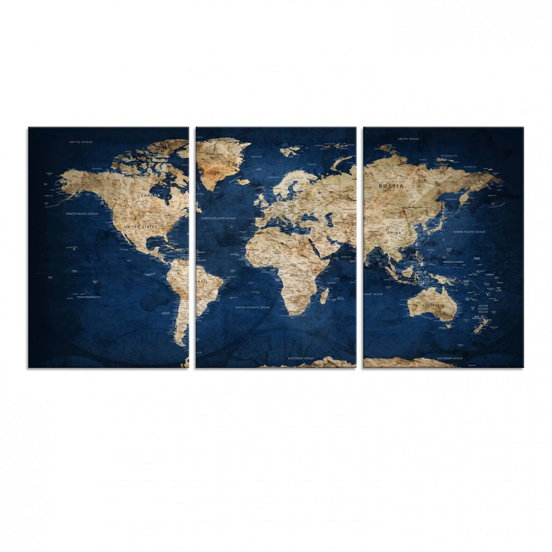 A large framed world map canvas print features beige landmasses set against a grunge-stained deep blue ocean background, creating an intriguing piece of wall art.