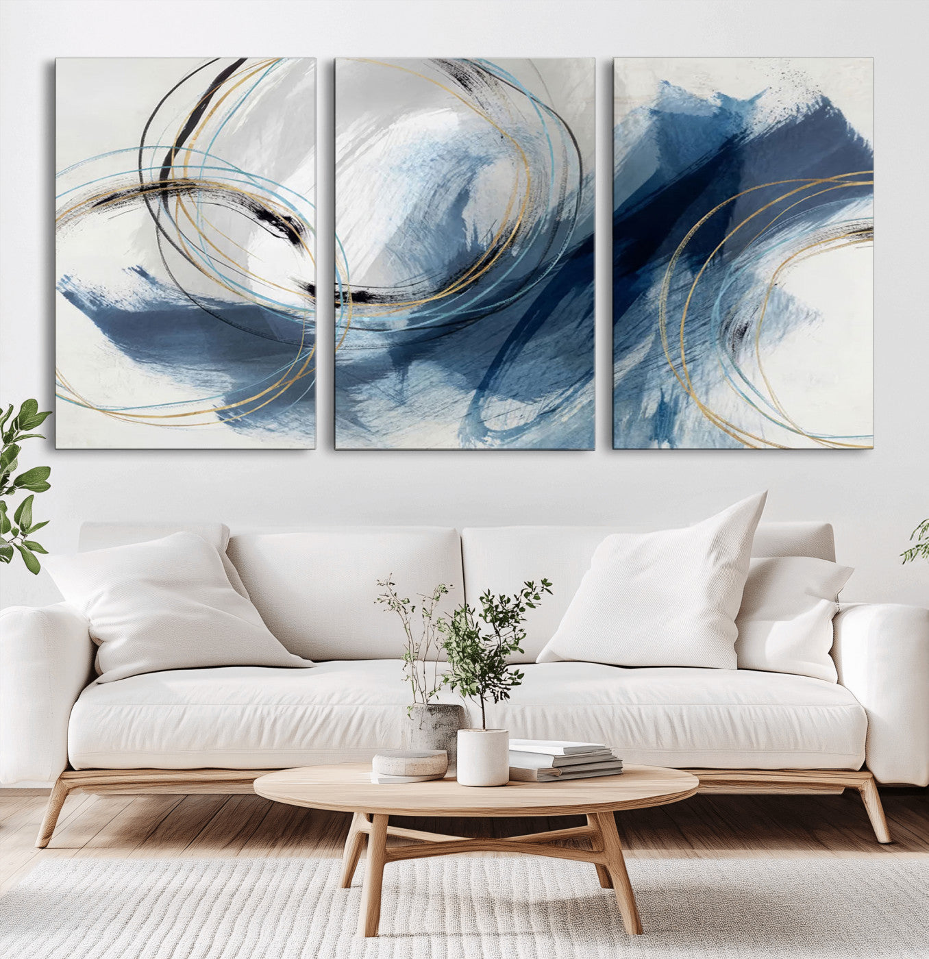 Abstract wall art featuring dynamic brush strokes in shades of blue and gray, overlaid with delicate circular line patterns in gold, black, and light blue on a white background.