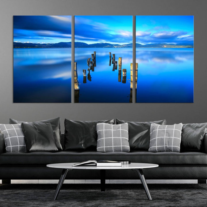 The Calm Waters Lake Canvas Art, featuring a tranquil pier reflection set against a mountainous backdrop, showcases its elegance with a gallery wrap and Canon print quality.