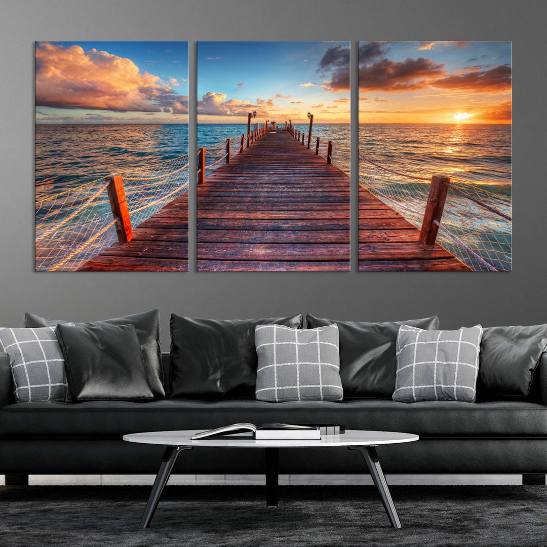 The Sunset Pier Canvas Wall Art is a triptych featuring an ocean landscape that elegantly captures a tranquil beach sunset with gentle ocean waves. It comes beautifully framed and ready to hang.