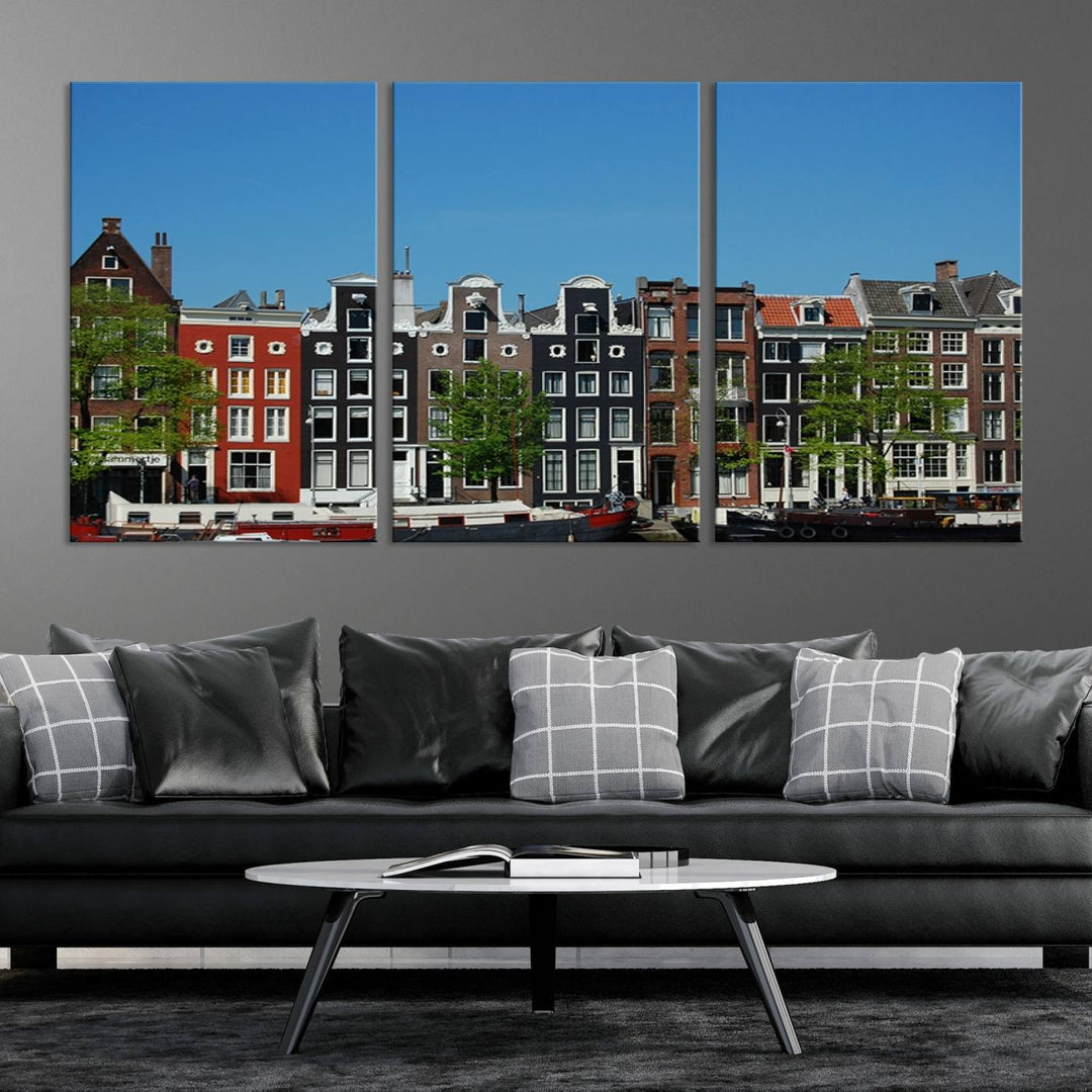 The Amsterdam City Wall Art Canvas Print showcases colorful traditional canal houses and boats set against a clear blue sky.