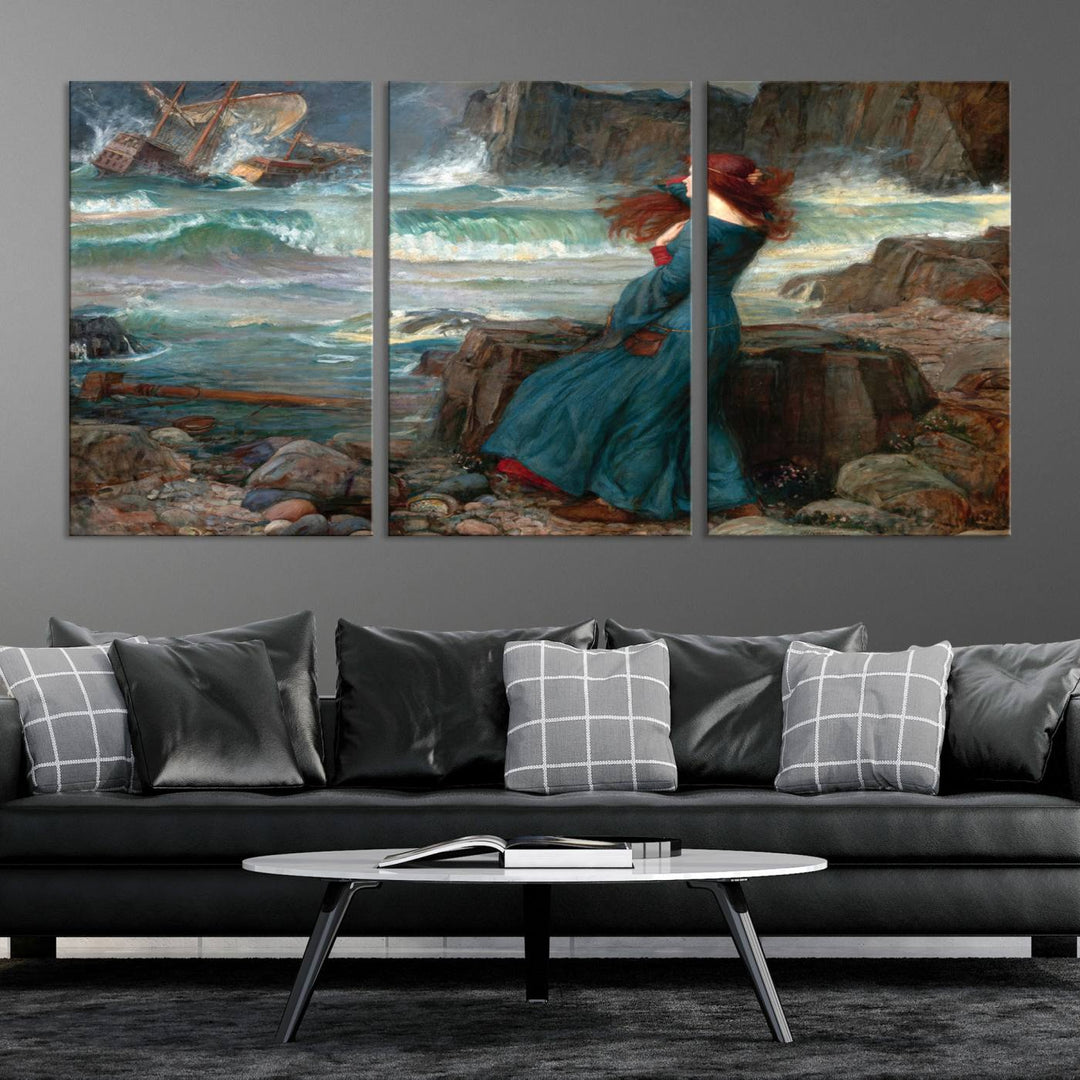 The Miranda by the Shore Wall Art Canvas Print depicts a woman in a blue dress standing by the sea, watching a shipwreck.