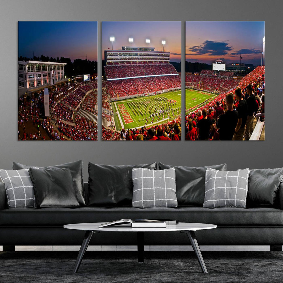 A print of a bustling Carter-Finley Stadium at dusk, featuring fans and a band, captures the essence of NC State Wolfpack football.