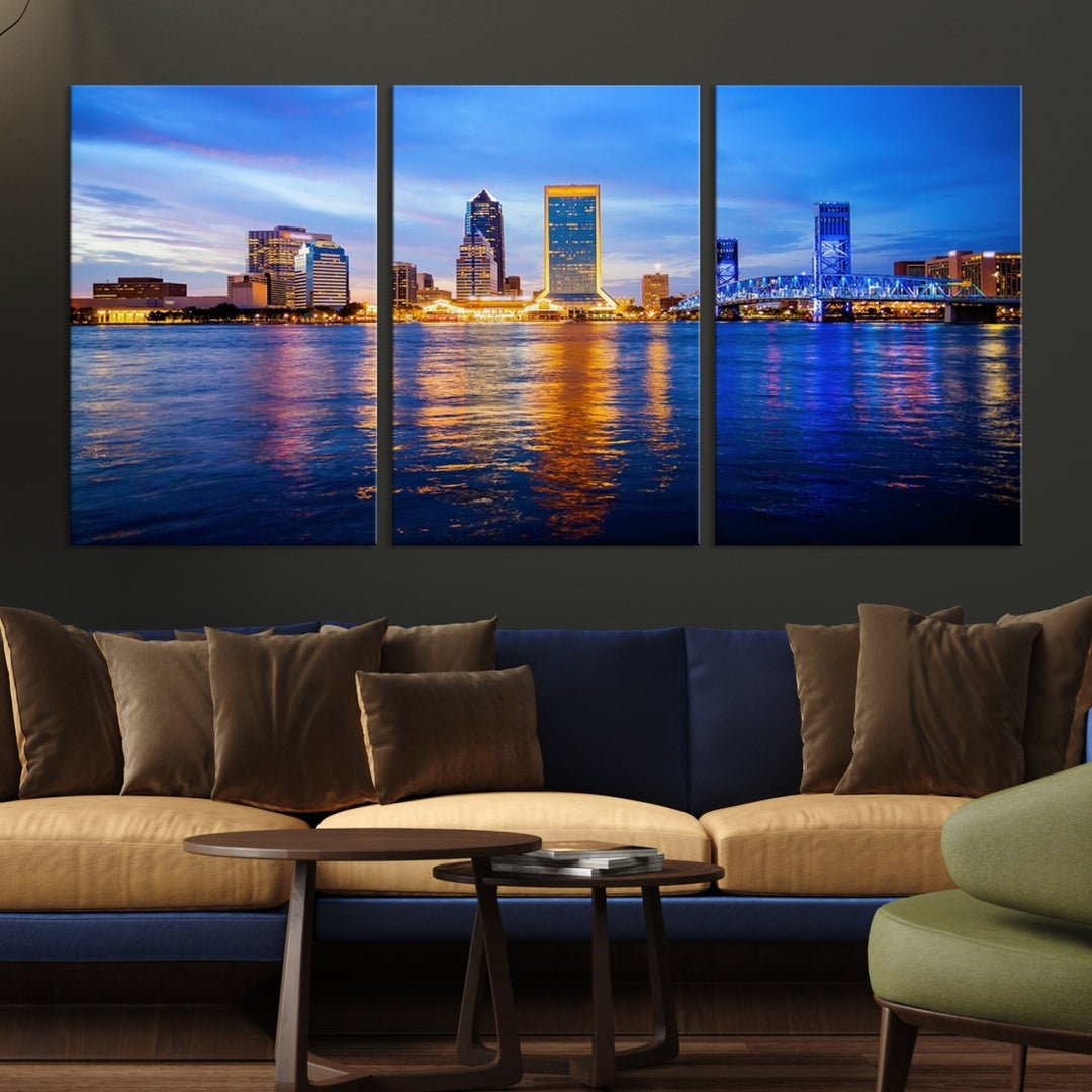 A cozy living room features the Jacksonville Wall Art Canvas Print, a large triptych crafted on museum-quality canvas that beautifully depicts the Jacksonville city skyline at sunset.