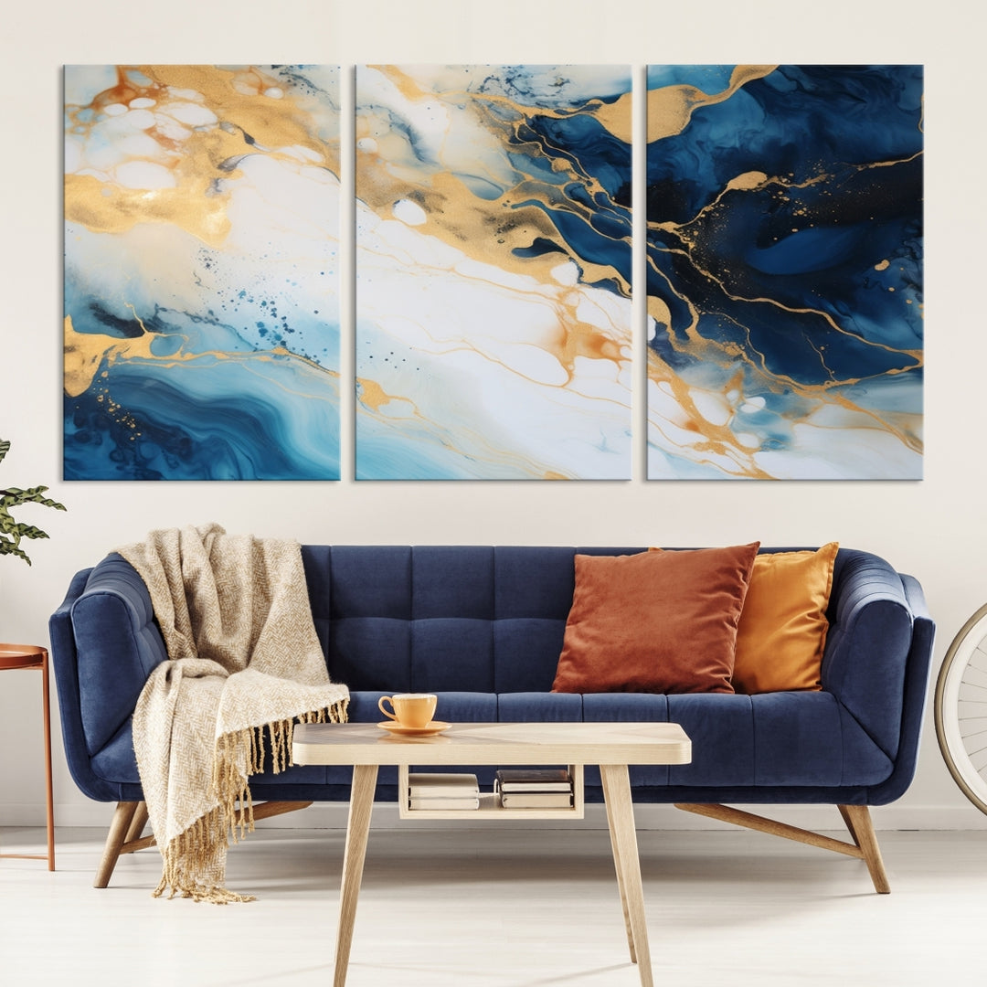 A modern living room featuring museum-quality Blue Gold Abstract Wall Art Print Contemporary art in a triptych arrangement.