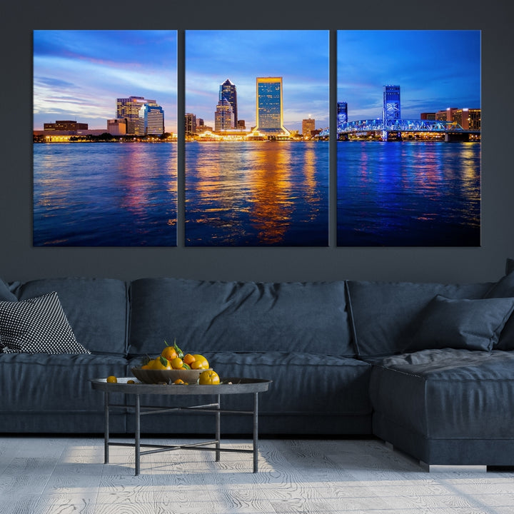 A cozy living room features the Jacksonville Wall Art Canvas Print, a large triptych crafted on museum-quality canvas that beautifully depicts the Jacksonville city skyline at sunset.