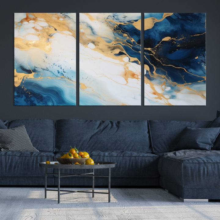 A modern living room featuring museum-quality Blue Gold Abstract Wall Art Print Contemporary art in a triptych arrangement.