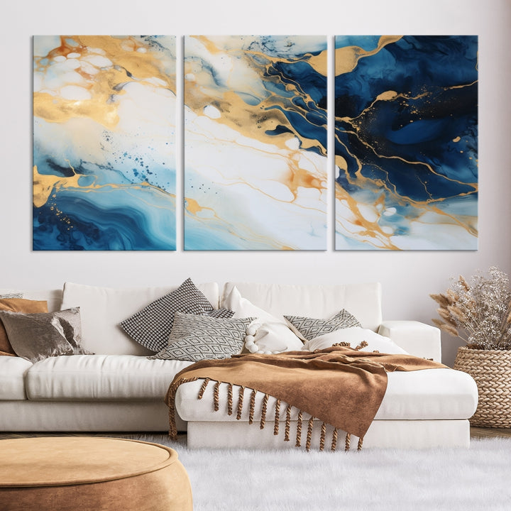 A modern living room featuring museum-quality Blue Gold Abstract Wall Art Print Contemporary art in a triptych arrangement.